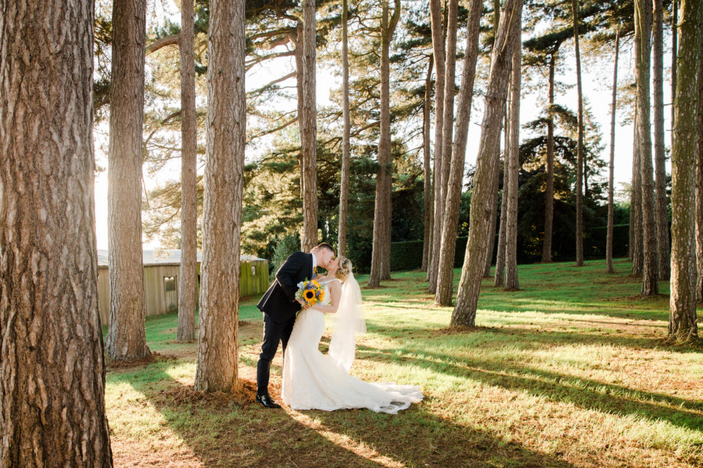 bride and groom kiss in the woods uk