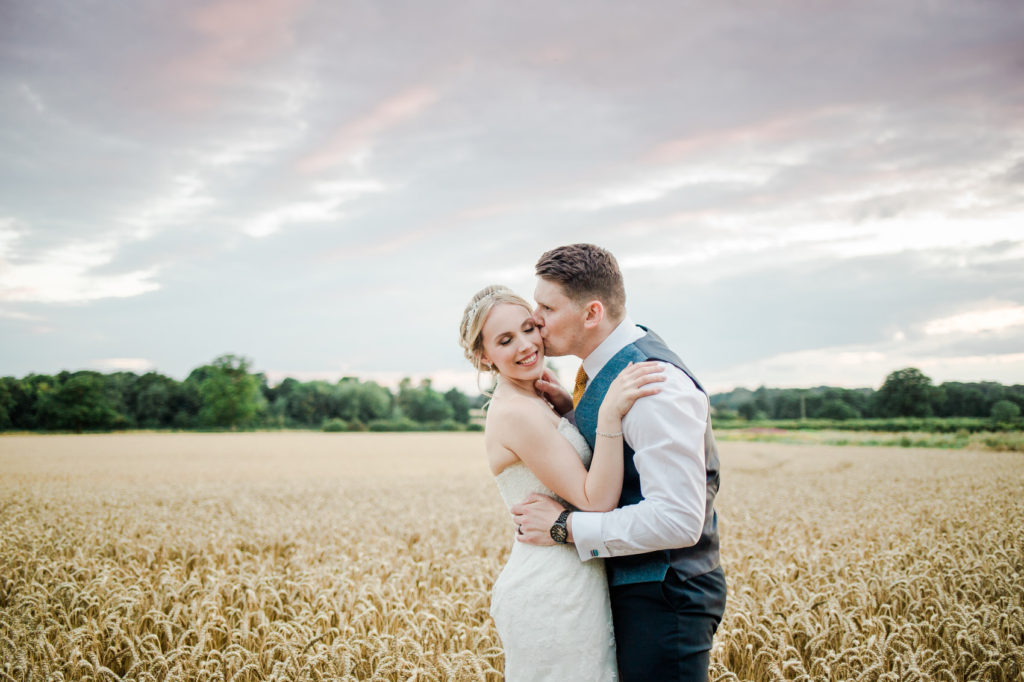 Yellow And Blue Rustic Barn Wedding couple in corn field farm wedding