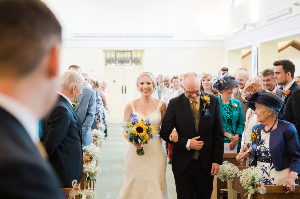 bride walking down aisle with her father