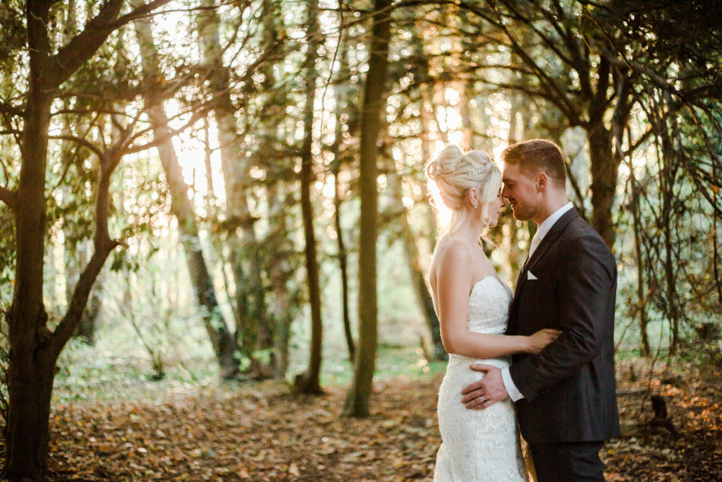 naturl relaxed photography bride and groom embrace in forest at golden hour