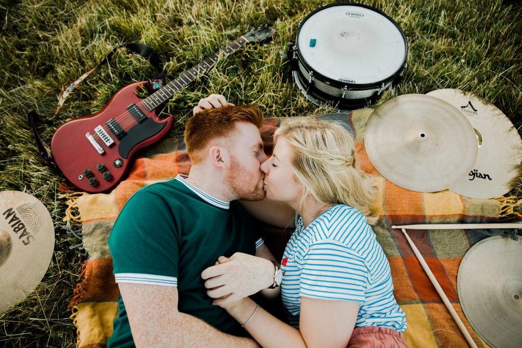 couple kiss among guitar and drums alternative music theme pre wedding shoot warwickshire